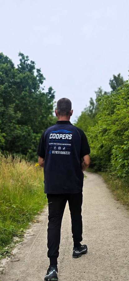 The owner of Coopers Car Cleaning Services walking a country path in a branded Coopers polo shirt